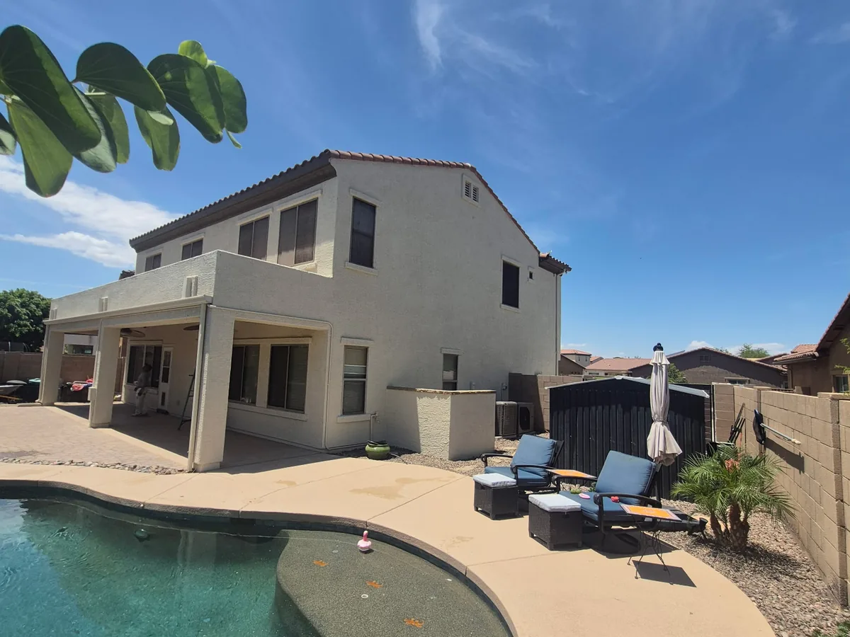 Backyard of a two story home with a pool