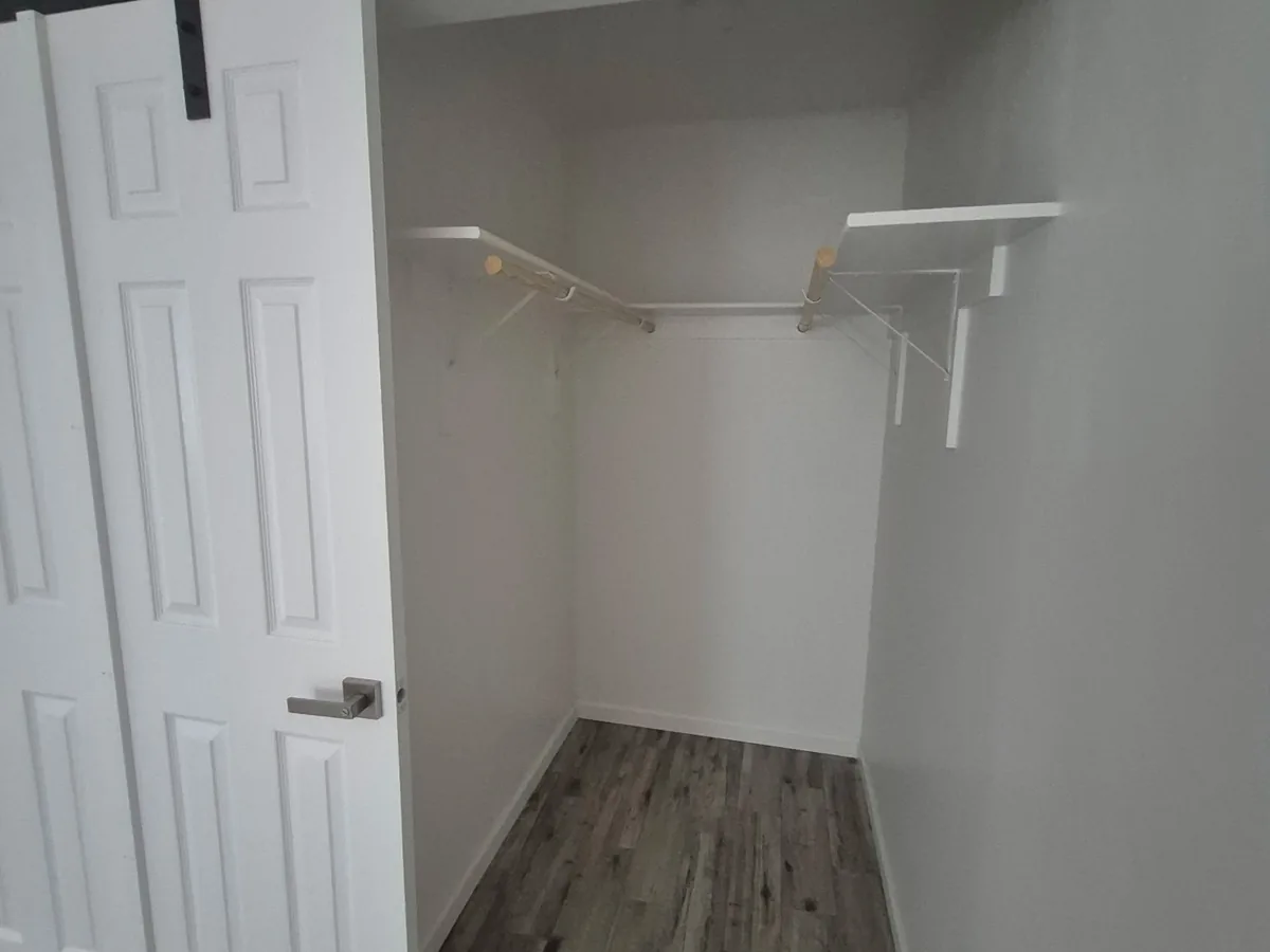 Small closet with white walls, wire shelving and a white six panel door