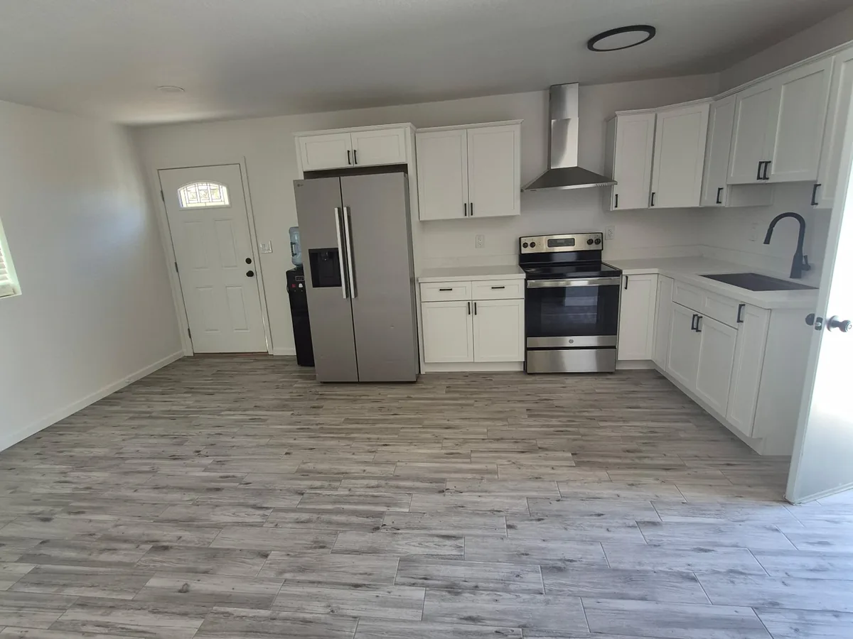 Kitchen with freshly painted white walls, white cabinets and stainless steel appliances